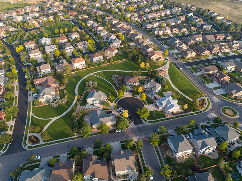 Brighton | rcastlemortgage.com Aerial view of a residential neighborhood in Brighton, Colorado, showcasing houses and green spaces from above. Great place for homeowning. Get a quote from Robert Castle Mortgage today.