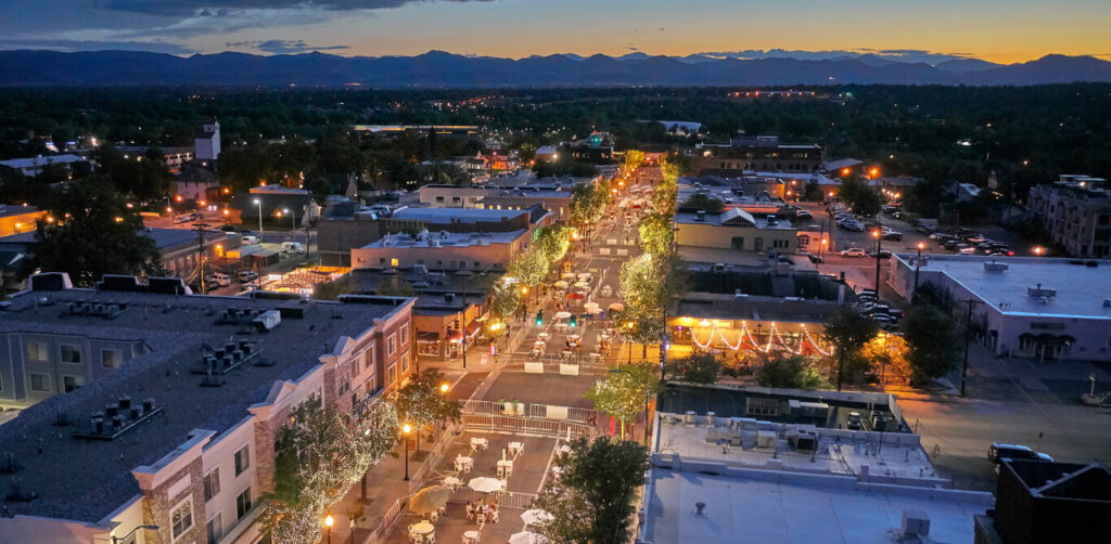 Littleton | rcastlemortgage.com Aerial view of Littleton, Colorado at dusk, showcasing the city skyline with mountains in the background. Great place for homeowning. Get a quote from Robert Castle Mortgage today.